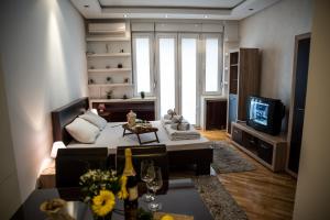 a living room with a couch and a tv at Balkan-inn Parlament apartment in Belgrade