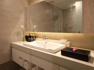 a bathroom with a white sink and a mirror at Puri Santrian in Sanur