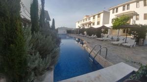 a swimming pool with blue water in front of some buildings at Emerald Heights in Tersephanou