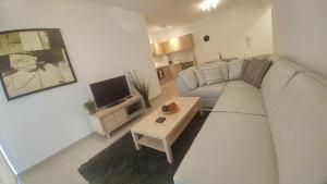 een woonkamer met een witte bank en een tafel bij Emerald Heights in Tersephanou