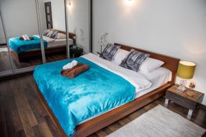 sypialnia z dużym łóżkiem i niebieskim kocem w obiekcie Dekart Arkadia Apartments w Warszawie