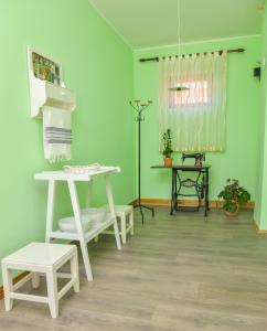 een kamer met groene muren en een tafel en banken bij etno dom "zuza" in Kovačica