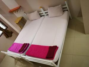 a large white bed with pink and purple sheets at Honey Place Guesthouse,special rate for long stay in Bangkok