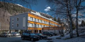un edificio con auto parcheggiate di fronte di Residence Kristall a Mezzana