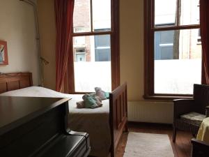 a bedroom with a bed with a teddy bear sitting on it at Smitsstraat B&B in Eindhoven