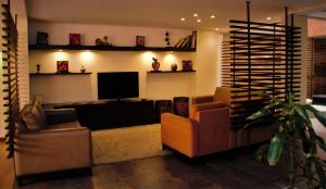 uma sala de estar com 2 cadeiras e uma televisão de ecrã plano em Scala 68 em Bogotá