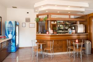 a bar in a restaurant with a refrigerator and stools at Hotel Crocenzi in San Marino