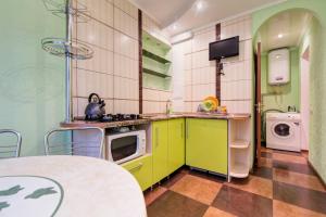 a kitchen with yellow and green cabinets and a washing machine at Apartment on Riverfront of Dnepr in Dnipro