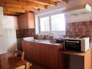 a kitchen with a microwave and a sink and a window at Villas Zoe in Skiathos