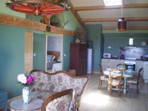 ein Wohnzimmer mit einem Tisch und Stühlen sowie eine Küche in der Unterkunft Le Clos des pins in Claira