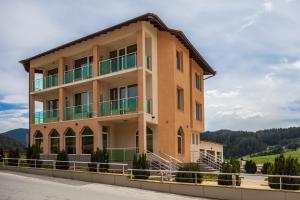 un edificio con balcones al lado de una carretera en Семеен хотел "Елеганс" - Борино en Borino