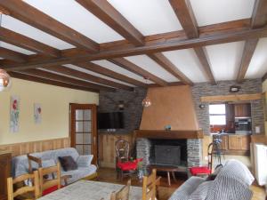 a living room with wooden ceilings and a fireplace at Le Chant de l'eau in Garin