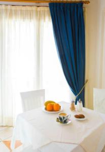 Hotel Niovi في ثيفا: طاولة بيضاء عليها صحن من البرتقال