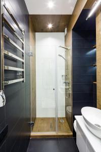 uma casa de banho com uma cabina de duche em vidro e um lavatório. em Brand new studio in historical part em Lviv