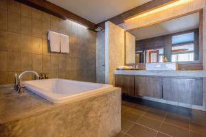 a large bathroom with a tub and a window at Naina Resort & Spa - SHA Extra Plus in Patong Beach +96 photos