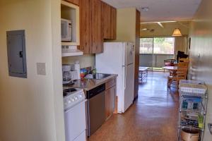 a kitchen with white appliances and a dining room at Kihei Bay Surf 117 in Kihei