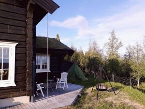 a porch of a log cabin with a swing and a tent at Blazerbu Four-Bedroom Chalet in Hol
