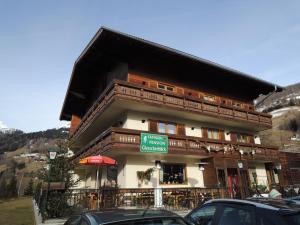 a large building with cars parked in front of it at Familienpension Gletscherblick in Heiligenblut