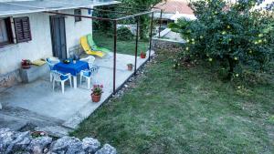 a patio with a table and chairs and an apple tree at Apartman Đina in Risika