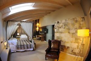 1 dormitorio con 1 cama y 1 silla en una habitación en La Posada de Mosqueruela, en Mosqueruela