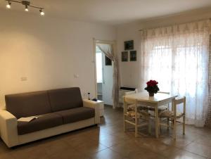 ein Wohnzimmer mit einem Sofa und einem Tisch in der Unterkunft House Orsa Maggiore by Holiday World in Bordighera
