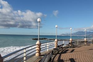 eine Reihe von Bänken auf einem Pier in der Nähe des Ozeans in der Unterkunft House Orsa Maggiore by Holiday World in Bordighera