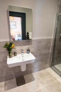 a bathroom with a sink and a mirror at The Fullerton Arms in Ballintoy +30 photos