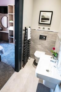 a bathroom with a toilet and a sink at The Fullerton Arms in Ballintoy