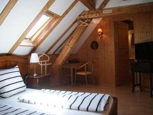 ein Schlafzimmer mit einem Bett und einem Schreibtisch im Dachgeschoss in der Unterkunft Gasthaus Alte Brauerei in Ettenheim