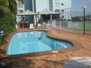 - une piscine sur une terrasse avec une table et des chaises dans l'établissement Fairthorpe Apartments, à Brisbane