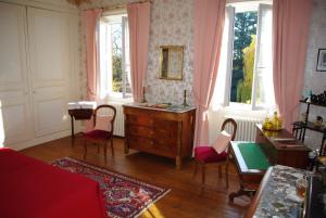 a room with a dresser and chairs and windows at Le Clos des Tanneurs in Taponas