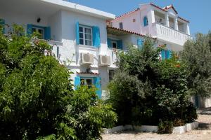 a large white house with blue windows and bushes at Pelagia in Marathokampos +30 photos