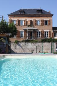 a house with a swimming pool in front of a building at Le Clos des Tanneurs in Taponas
