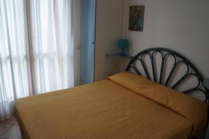 a bedroom with a bed and a window with curtains at Villa Caprera in Rosolina Mare +19 photos
