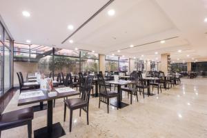 een eetkamer met tafels en stoelen en ramen bij Be Live Experience Orotava in Puerto de la Cruz