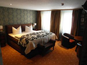 バート・ローベンシュタインにあるPension Antikのベッドと椅子付きのホテルルーム