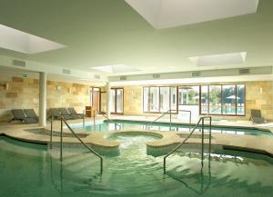 een zwembad in een gebouw met een zwembad bij Tisza Balneum Hotel in Tiszafüred