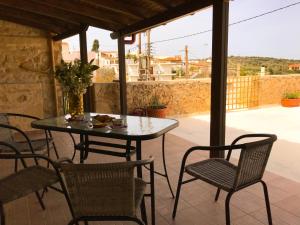 a table and chairs sitting on a patio with a table and chairs at Antonia’s Home Alfa Village in Alfá