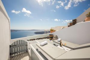 a white balcony with a view of the ocean at Ethereum Luxury Cave in Imerovigli