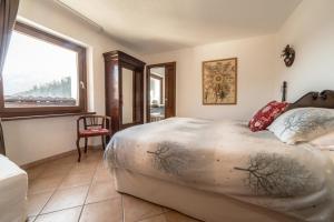 a bedroom with a large bed and a window at Lo Verdzé di Torgnon in Torgnon