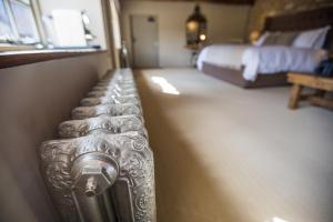 1 dormitorio con 1 cama y 1 maleta de plata en The Porch House, en Stow on the Wold