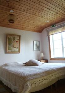 a bedroom with a large bed with a wooden ceiling at Lamminkangas Cottage in Kalmari