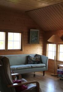 una sala de estar con un sofá azul en una cabaña en Lamminkangas Cottage, en Kalmari