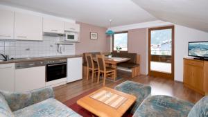 eine Küche und ein Wohnzimmer mit einem Tisch und Stühlen in der Unterkunft Landhaus Tyrol in Mayrhofen