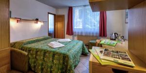 una camera d'albergo con un letto e un libro su un tavolo di Residence Kristall a Mezzana