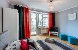 1 dormitorio con cortinas rojas, 1 cama y TV en ClickTheFlat Żurawia Street Apart Rooms en Varsovia