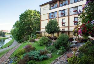 a hotel with a garden in front of a building at Romantic Boutique Hotel & Spa in Panevėžys