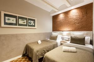 Zimmer mit 2 Betten und Ziegelwand in der Unterkunft Fuster Apartments by Aspasios in Barcelona