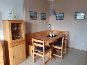 a dining room with a wooden table and chairs at PEKW6A103-FeWo-Kievitt in Petersdorf auf Fehmarn