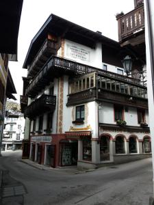 un grand bâtiment au coin d'une rue dans l'établissement Haus Alpenrose, à Sankt Wolfgang im Salzkammergut